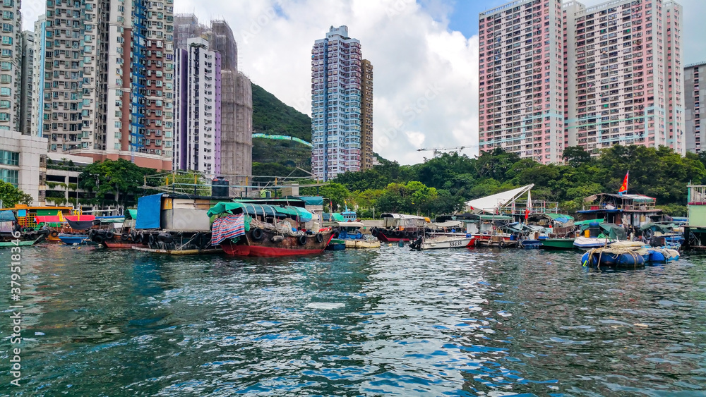 Fototapeta premium City lake with buildings and fishing boats in the background