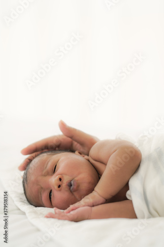 african american new born baby lying on white bed