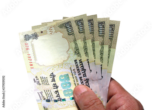 Close-up of hand holding Indian currency or INR 500 bank notes ,isolated on white