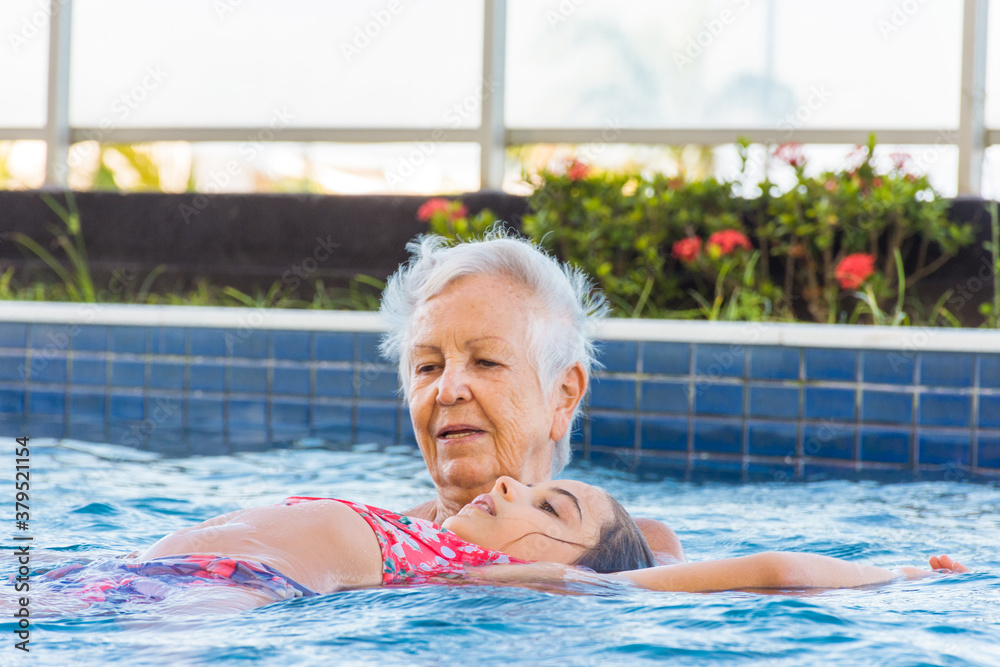 Fototapeta premium Idosa faz relaxamento com criança na piscina