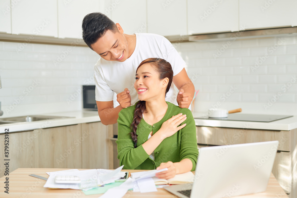 Guy is doing massage his girlfriend while she is working with a laptop Guy is doing massage his girlfriend while she is working with a laptop