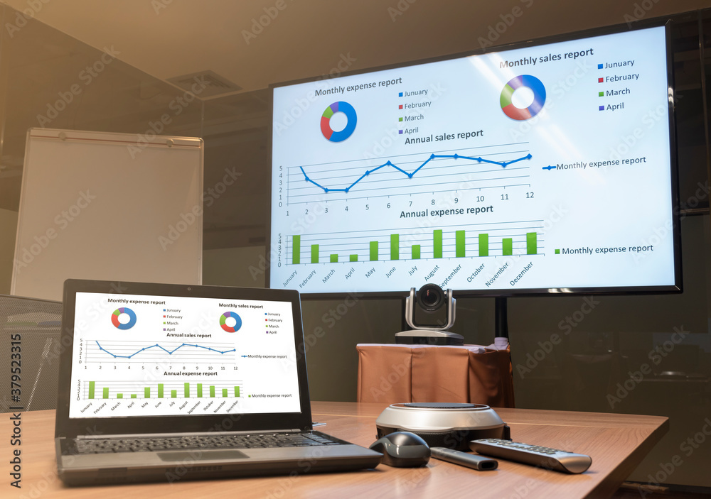 Close up laptop on table with Presentation meeting on television in Video conference meeting room (Work from home Concept) Close up laptop on table with Presentation meeting on television in Video conference meeting room (Work from home Concept)