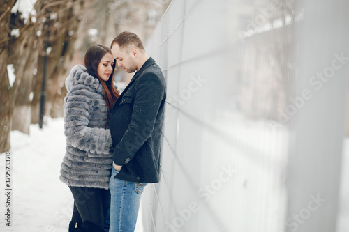 Cute couple walking in a winter city. Elegant woman in a gray fur coat © hetmanstock2