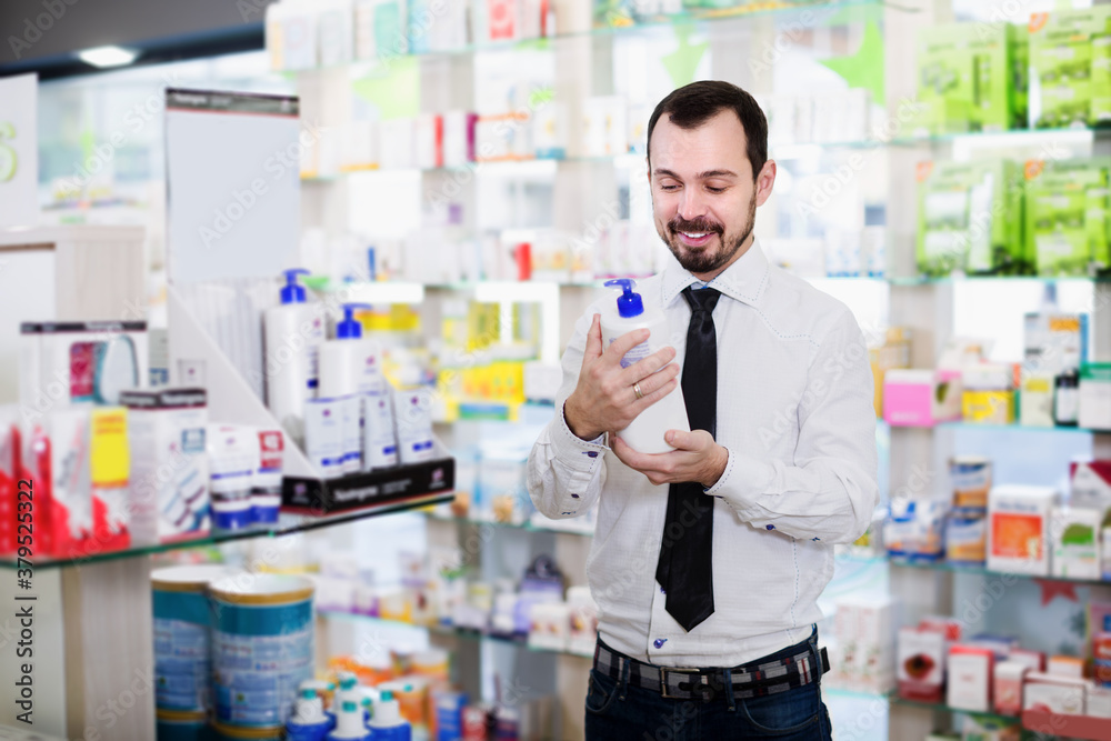 Smiling man client looking assortment in drugstore