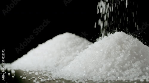 Coarse grains of sea salt falling in a heap