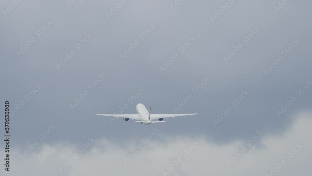 Back view of large generic widebody commercial passenger airplane departing from an airport with passengers on board going on vacation. Back view of large generic widebody commercial passenger airplane departing from an airport with passengers on board going on vacation.