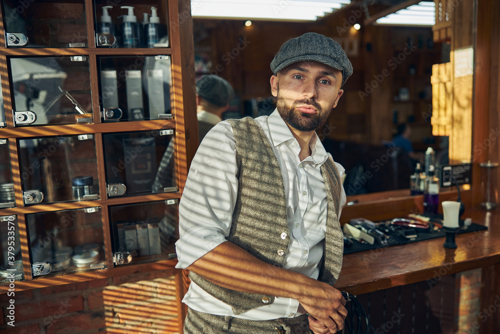 Stylish man wearing a peaky hat at a barbershop
