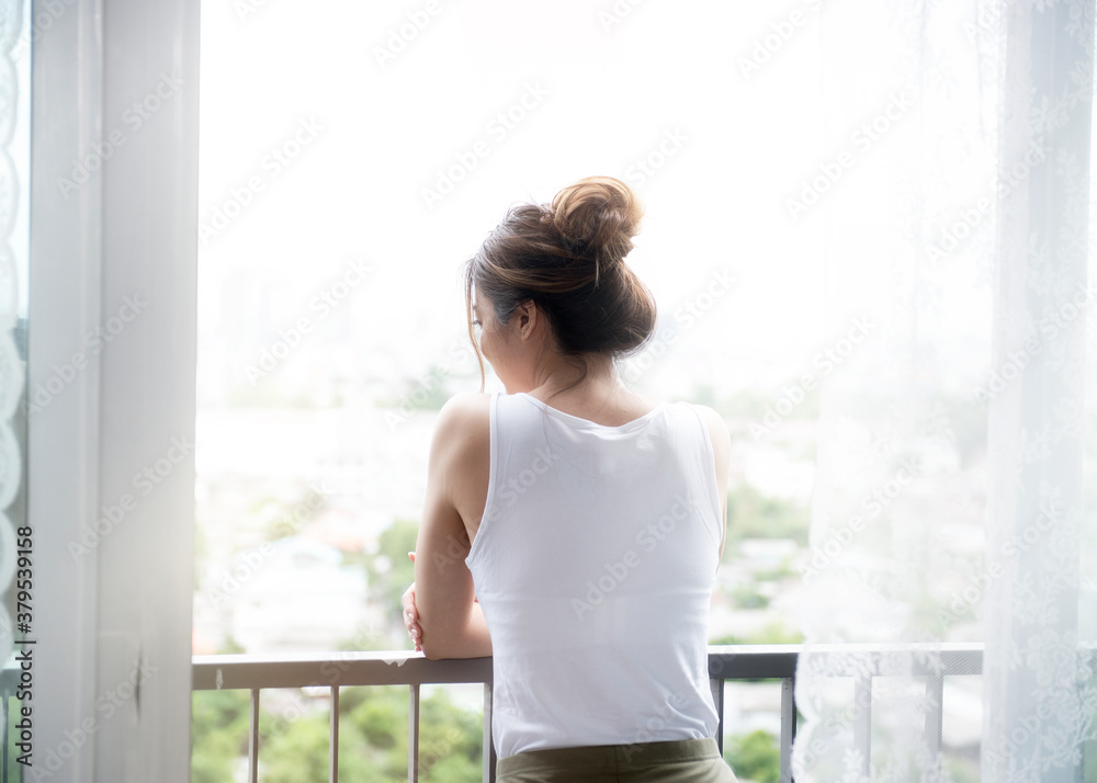 Rear back view young happy brunette woman standing looking outside, enjoying view at hotel home, good morning lifestyle concept.