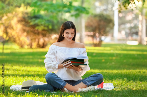 Beautiful young woman reading book in park © Pixel-Shot