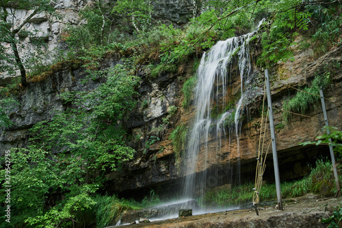 view of a small mountain river waterfall among large cobblestones from a cliff. photo