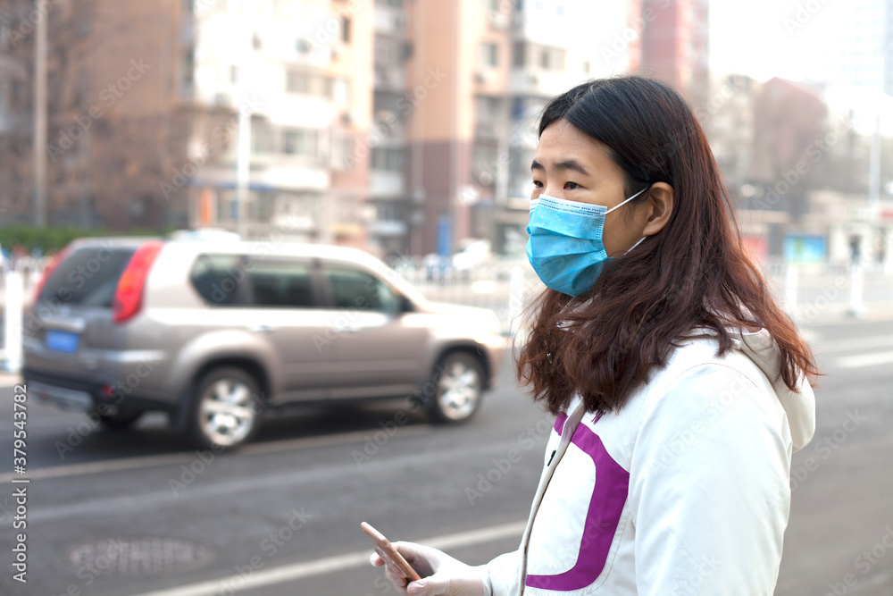 Women wearing masks are waiting for the bus during the epidemic
