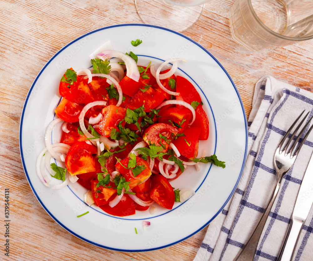 Vegetable salad with fresh tomatoes, sliced onion and olive oil