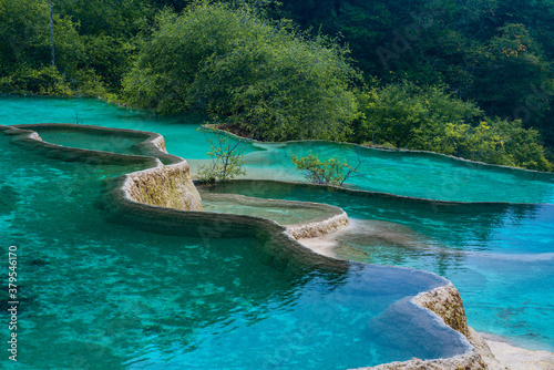The turquoise color hot spring pools in Huanglong Valley  Sichuan  China  on summer time.