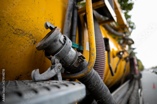 Tablou pe pânză Side view of powerful professional modern yellow sewage sewerage truck working n