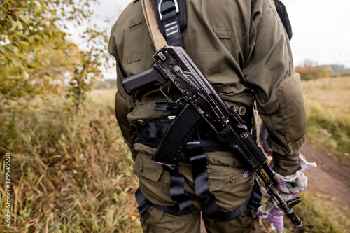 Soft focus. Soldier in camouflage holding a finger on the trigger of a Kalashnikov, Special forces team. Russian police (Spetsnaz).