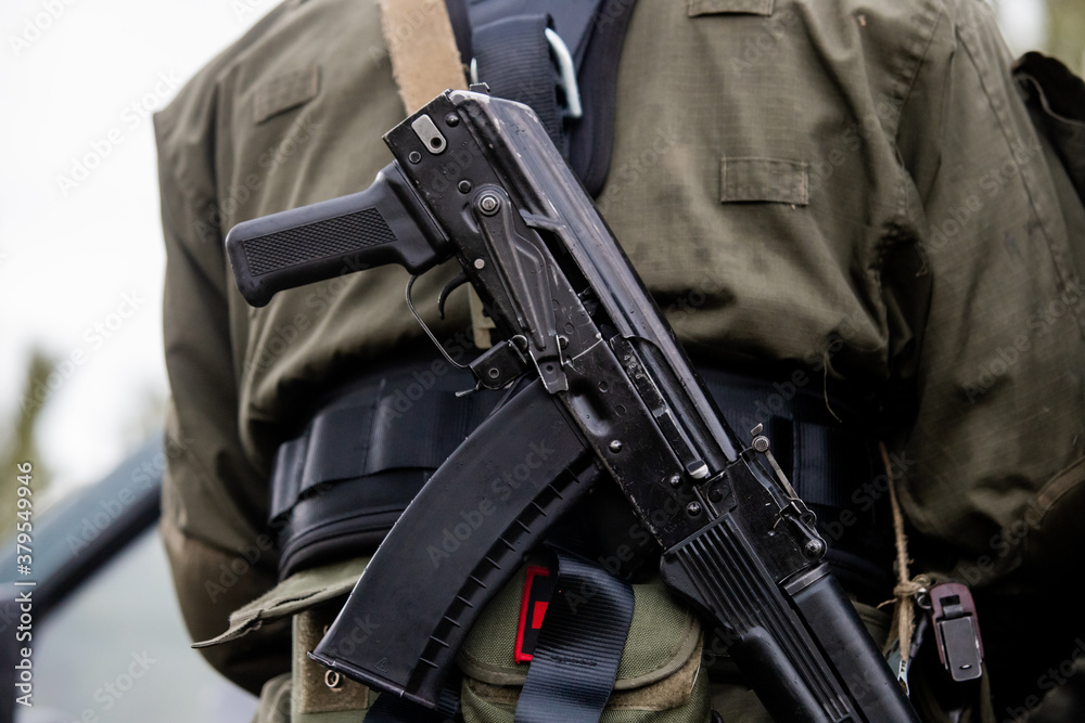 Soft focus. Soldier in camouflage holding a finger on the trigger of a Kalashnikov, Special forces team. Russian police (Spetsnaz). Soft focus. Soldier in camouflage holding a finger on the trigger of a Kalashnikov, Special forces team. Russian police (Spetsnaz).