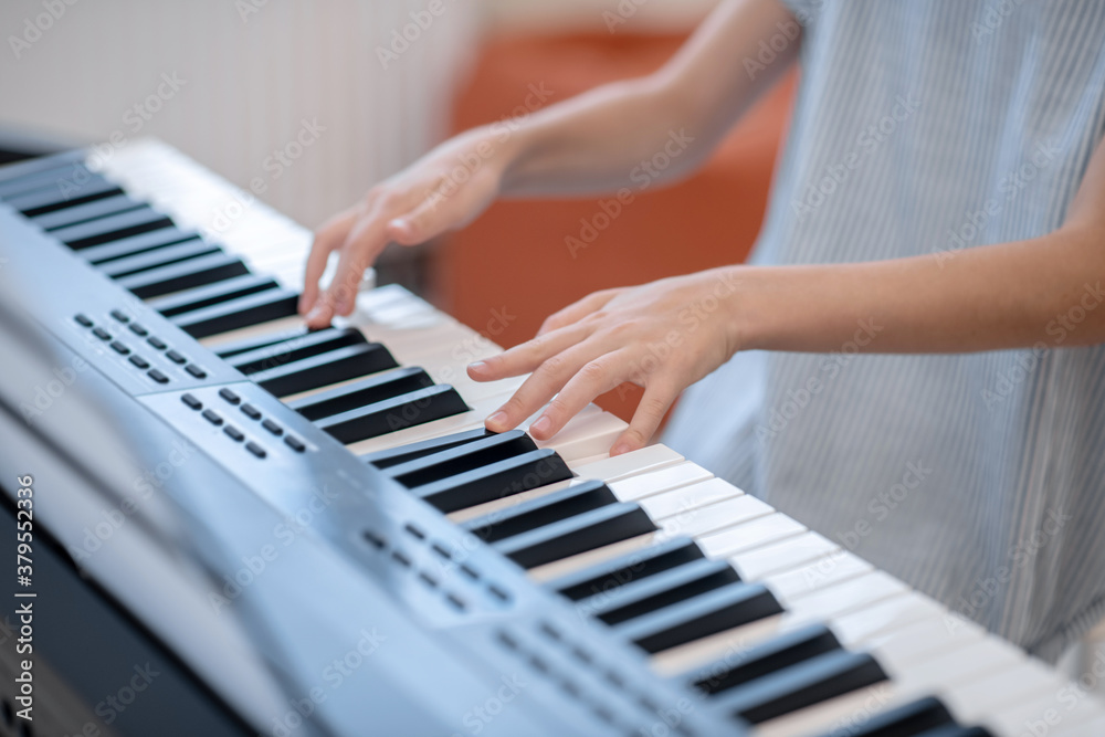 Fototapeta premium Close up picture of a girl playing on synthesizer
