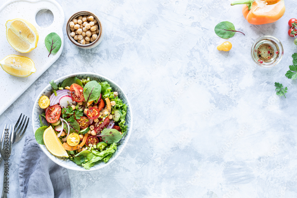 Fresh vegetable salad in a plate on a white stone background. Top view Fresh vegetable salad in a plate on a white stone background. Top view