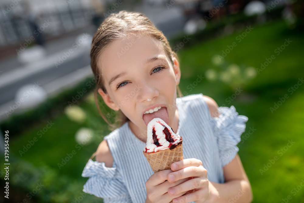 Cute girl eating ice-cream and looking happy Cute girl eating ice-cream and looking happy