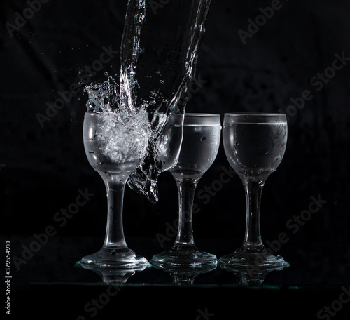 glasses with water with splashes on a black background