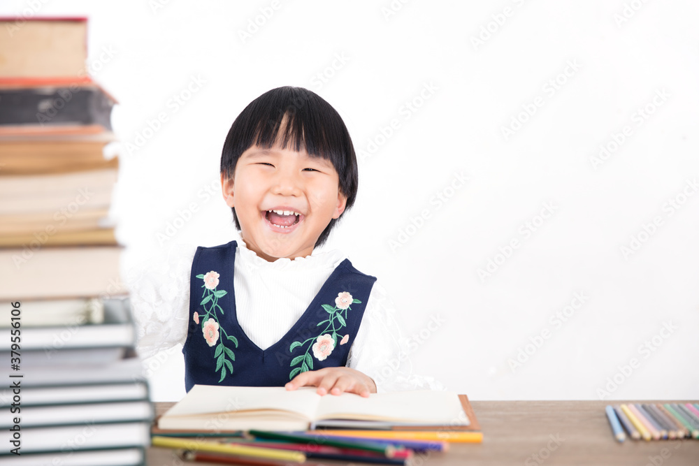 The child who was studying suddenly looked at the camera and laughed The child who was studying suddenly looked at the camera and laughed