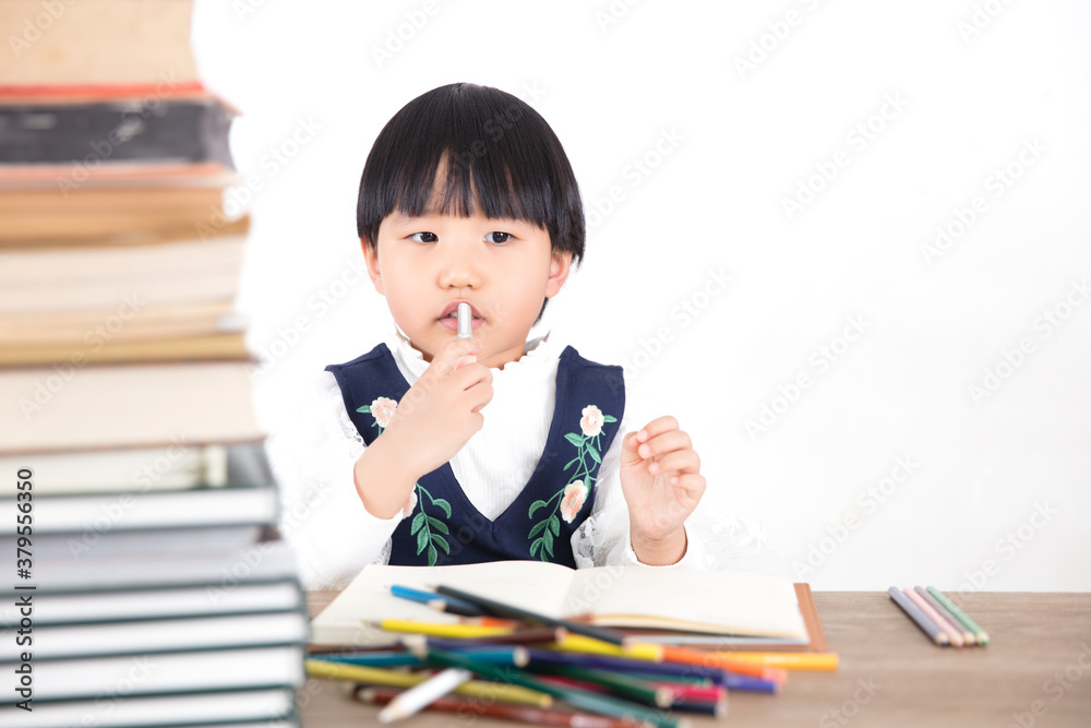 Little girl rubbing her mouth while studying Little girl rubbing her mouth while studying