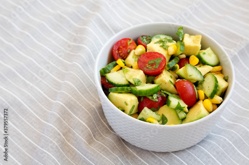 Fresh Avocado Tomato Salad in a bowl  low angle view. Copy space.