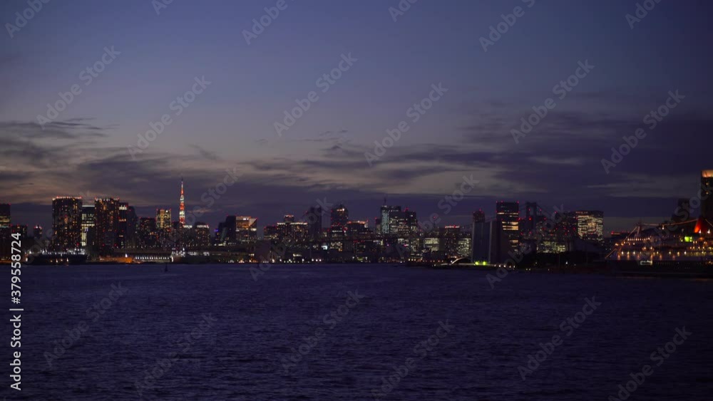Tokyo skyline at dusk filmed from ship in Tokyo harbor - handheld shot Tokyo skyline at dusk filmed from ship in Tokyo harbor - handheld shot