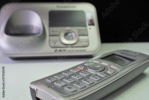 Cordless telephone placed on office desk table.