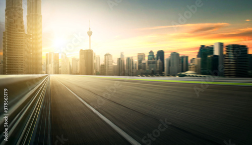 Asphalt road of Modern city with skyscrapers as background. Motion blur effect