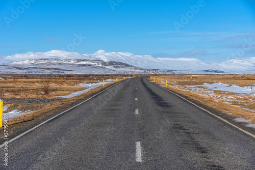 Highway road with snow and blue clear sky in Iceland.