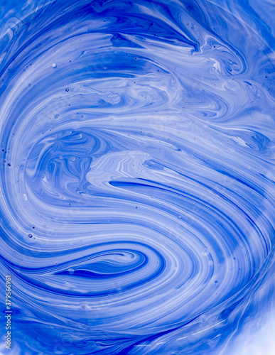 Mixing white and blue paints Contemporary art. Bright abstract background with space for text
