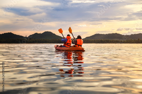 Tourist paddling the kayak on the sea among the beautiful scenery during sunset at koh pitak , chumphon province in Thailand. This is very popular for photographers and tourists.