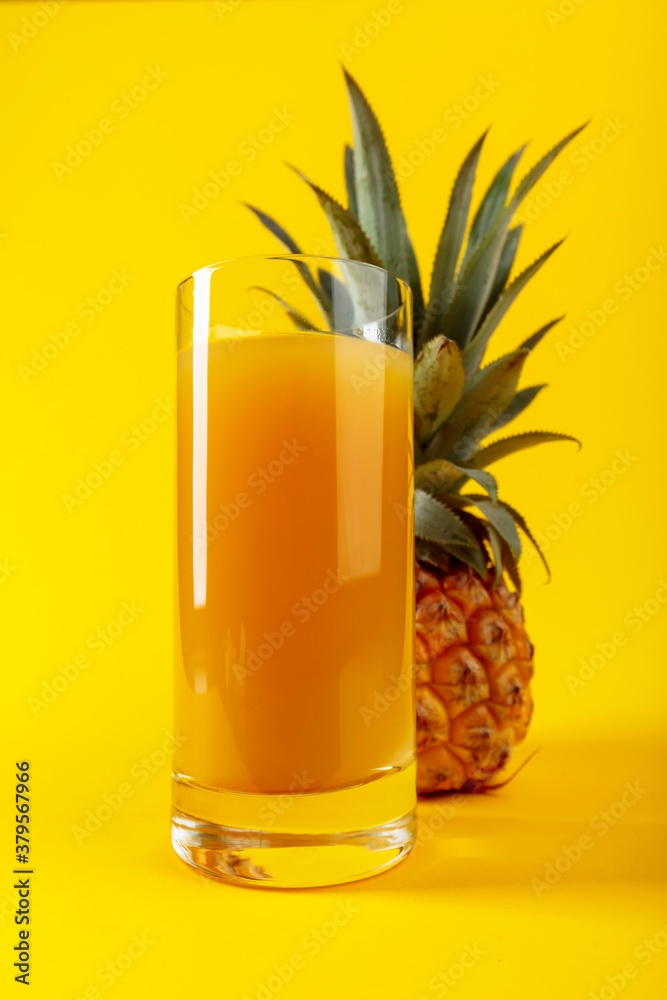 Ripe pineapple and juice on a yellow background. Ripe pineapple and juice on a yellow background.
