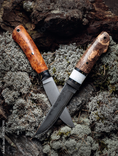 Hunter combat hand made knife on a moss in forest. photo