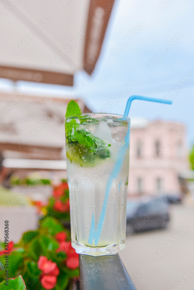 Cold summer fruit and berries lemonade. Mojito lemonade in a glass with a plastic straw outside. Cold summer fruit and berries lemonade. Mojito lemonade in a glass with a plastic straw outside.