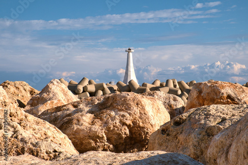 Old lighthouse in the Mediterranean sea harbor of fishing village Zygi on Cyprus on a sunny day photo