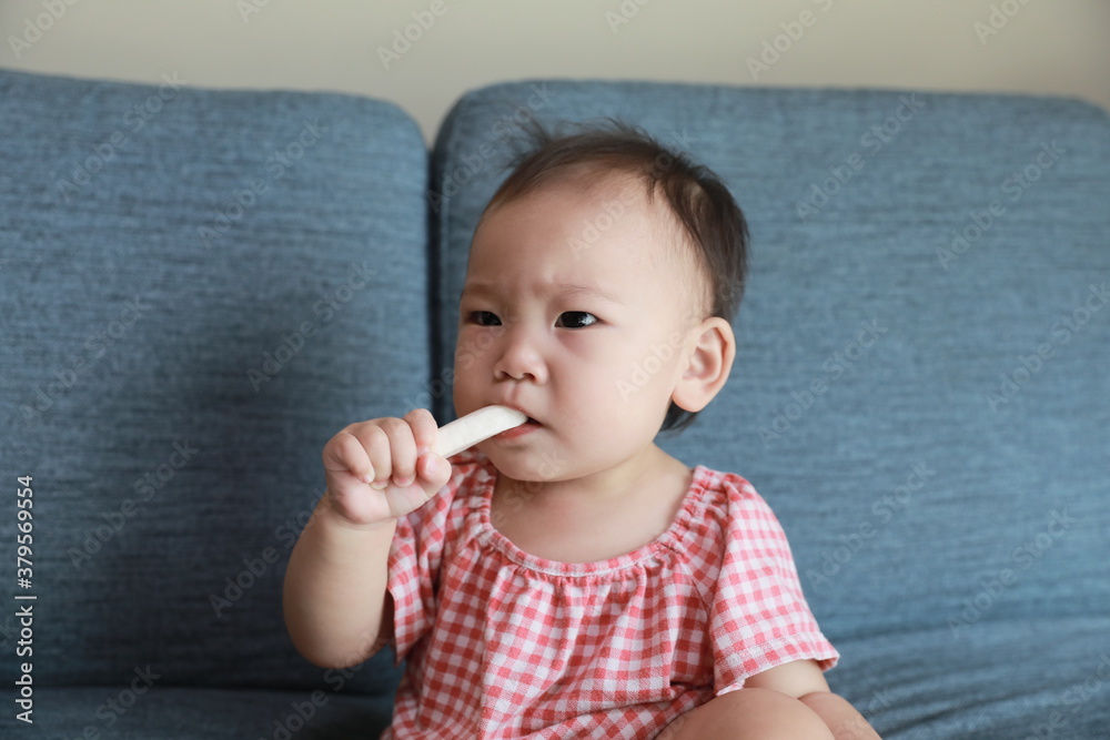 a frowning baby with a cookie bite. a frowning baby with a cookie bite.