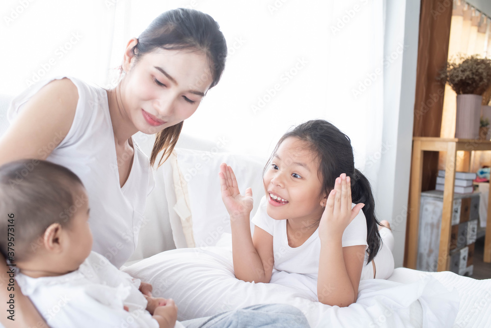 happy loving family. Love, trust and tenderness concept. Mother and child on a white bed. Parent and little kid relaxing at home. Mother and her daughters children girls playing and hugging. happy loving family. Love, trust and tenderness concept. Mother and child on a white bed. Parent and little kid relaxing at home. Mother and her daughters children girls playing and hugging.