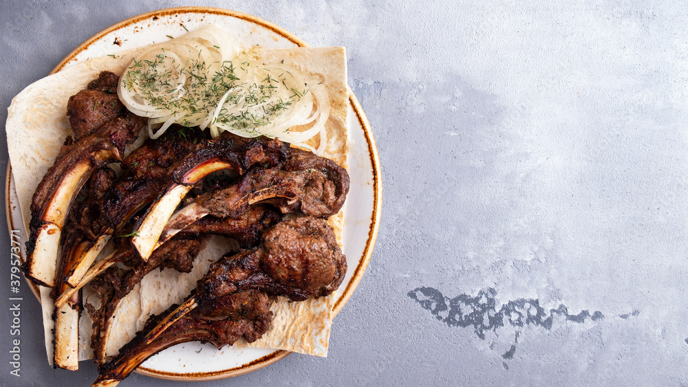 Juicy grilled lamb meat with onion on a plate. Top view. Copy space. Juicy grilled lamb meat with onion on a plate. Top view. Copy space.