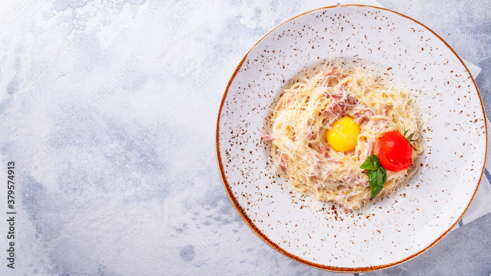 Pasta alla carbonara with bacon, egg, parmesan cheese and cream sauce. Classic Italian food. Top view. Text space Pasta alla carbonara with bacon, egg, parmesan cheese and cream sauce. Classic Italian food. Top view. Text space