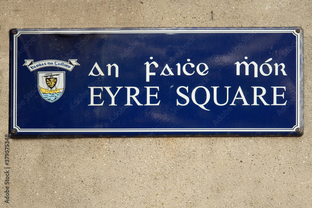 Sing Eyre Square in Irish and English language with town emblem on a light color wall. Galway city, Ireland Sing Eyre Square in Irish and English language with town emblem on a light color wall. Galway city, Ireland