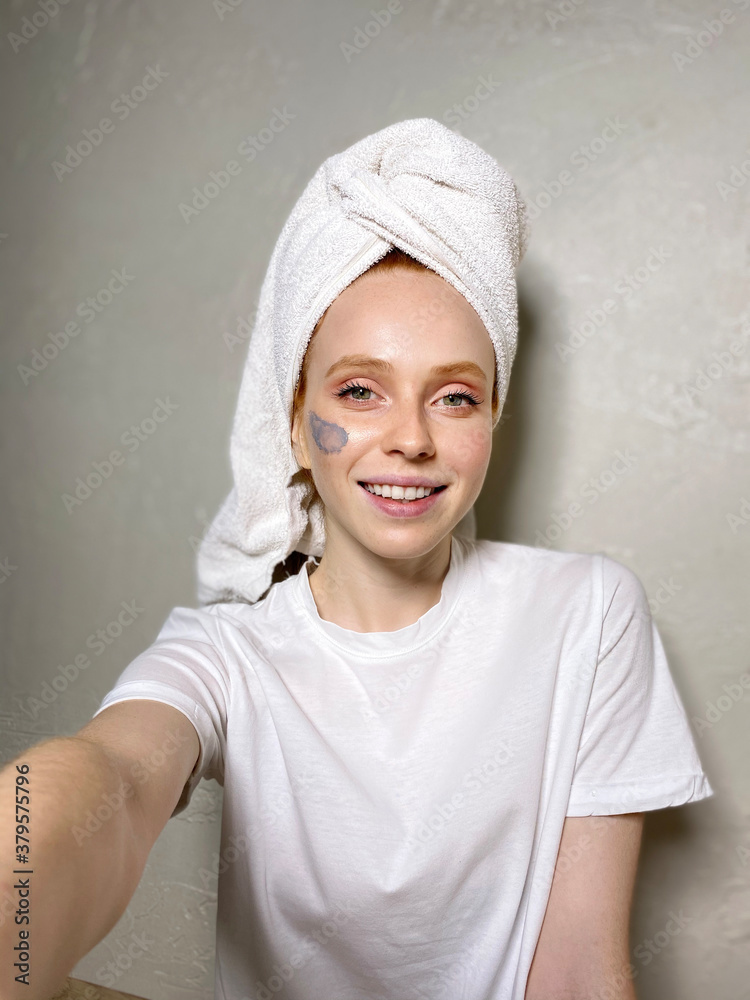 Charming woman with a towel on her head takes a selfie photo. Charming woman with a towel on her head takes a selfie photo.