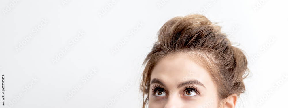 Half face of beautiful young caucasian woman looking up on white background. Girl looking upwards with copy space Half face of beautiful young caucasian woman looking up on white background. Girl looking upwards with copy space
