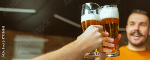 Happy. Hands of friends, colleagues during beer drinking, having fun, clinking bottles, glasses together. Flyer with copyspace. Oktoberfest, friendship, togetherness, happiness holidays concept