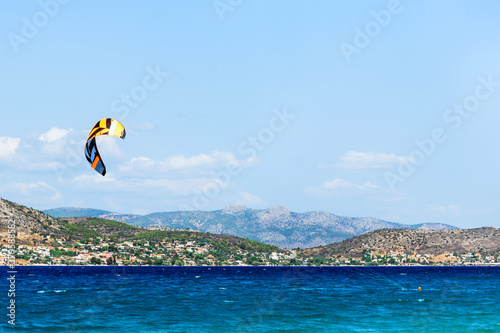  Kitesurfing on the sea. Colorful kites fly in the blue sky.