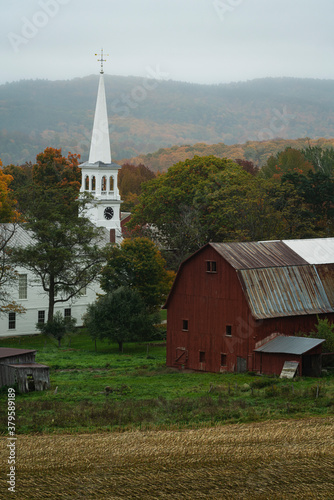 Rustic farm scene in rural vermont during autumn with fall colors changing and a bountiful harvest and a traditional American scene depicting home for the holidays