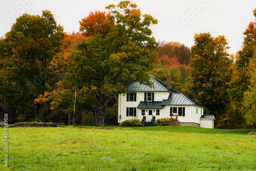 Rustic farm scene in rural vermont during autumn with fall colors changing and a bountiful harvest and a traditional American scene depicting home for the holidays photo