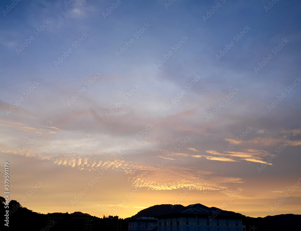 Obraz premium Beautiful view of sunset sky with dramatic light ,silhouette view of mountain and building