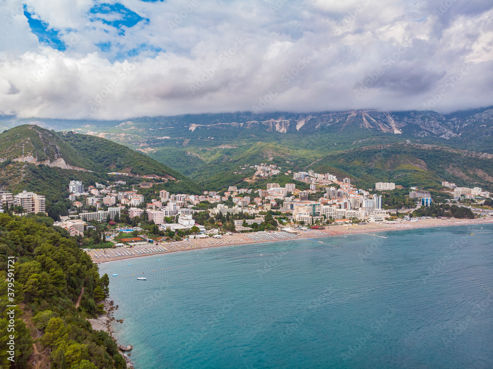 Beautiful view from sea to the resort town of Becici on background of mountains, Montenegro. Drone aerial photo